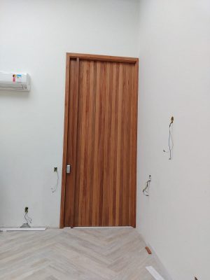 Porta pivotante modelo ripado na vertical, puxador em madeira no tamanho da porta, pintura verniz P.U acetinado