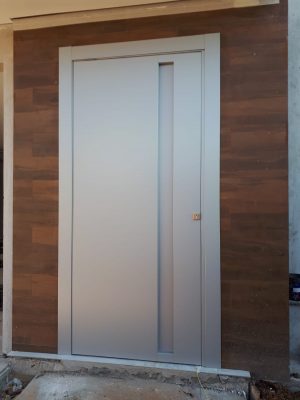 Porta pivotante em ACM cinza, puxador cava e dupla vedação