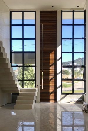 Porta pivotante com estrutura de aço no interior, revestimento com lambril maciço, porta com 8 cm de espessura