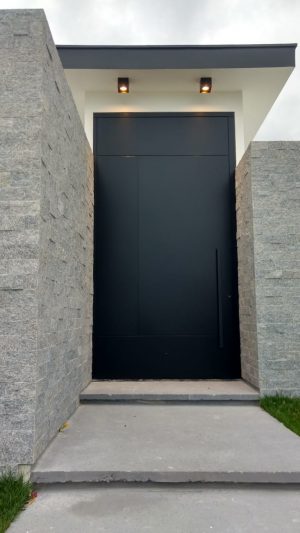 Porta pivotante em ACM preto carbono com frisos, dupla vedação