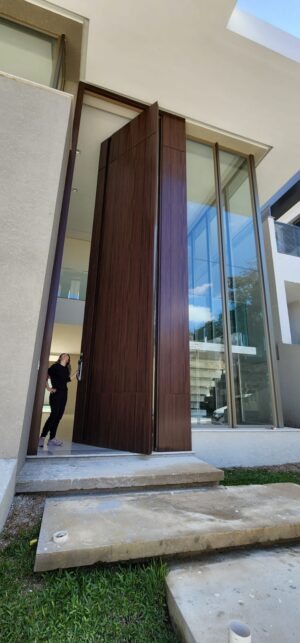 Porta pivotante em ACM com puxador cava e dupla vedação porta e batente