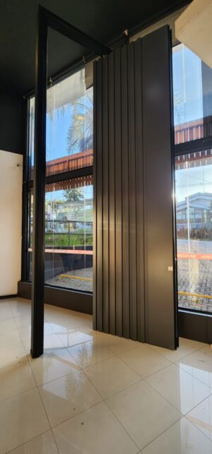 Porta pivotante em ACM ripado na vertical cor Dark Grey e dupla vedação - Imagem 2