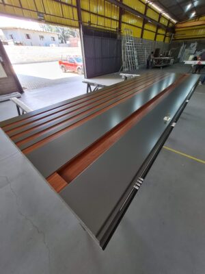 Porta pivotante em ACM Dark Gray, ripado na vertical em ACM mogno, puxador cava com LED, dupla vedação porta e batente - Imagem 8