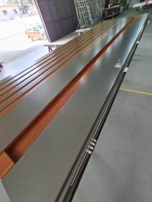 Porta pivotante em ACM Dark Gray, ripado na vertical em ACM mogno, puxador cava com LED, dupla vedação porta e batente - Imagem 11