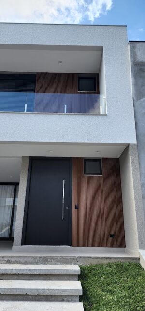 Porta pivotante em ACM preto fosco, painel fixo ripado madeirado, dupla vedação porta e batente - Imagem 2