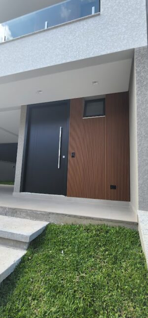 Porta pivotante em ACM preto fosco, painel fixo ripado madeirado, dupla vedação porta e batente - Imagem 6