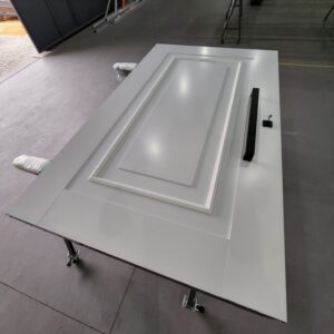 Porta pivotante em ACM branco neve com moldura e almofada, dupla vedação porta e batente