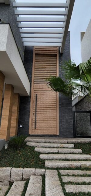 Porta pivotante em ACM modelo ripado na horizontal, vidro superior fixo com 10mm temperado, ACM revestido por cima do vidro, dupla vedação porta e batente