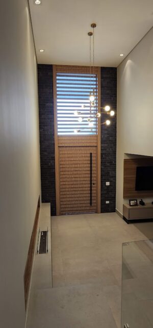 Porta pivotante em ACM modelo ripado na horizontal, vidro superior fixo com 10mm temperado, ACM revestido por cima do vidro, dupla vedação porta e batente - Imagem 9