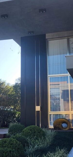 Porta pivotante em ACM com detalhe de inox, dupla vedação porta e batente