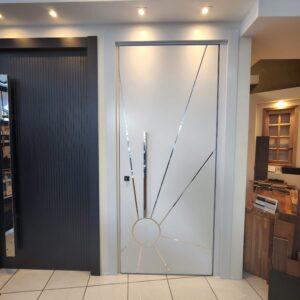 Porta pivotante em ACM branco com desenho do sol com inox brilhante, dupla vedação porta e batente - Imagem 2