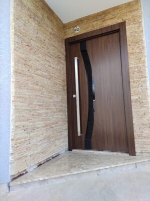 Porta pivotante em ACM madeirado Sucupira, modelo com vidro curvo fume, dupla vedação porta e batente - Imagem 2