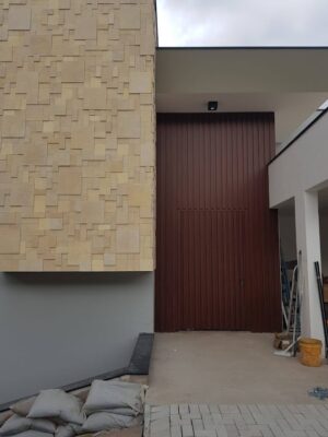 Porta pivotante em ACM modelo ripado vertical puxador cava no prórprio ripado e dupla vedação porta e batente - Imagem 2