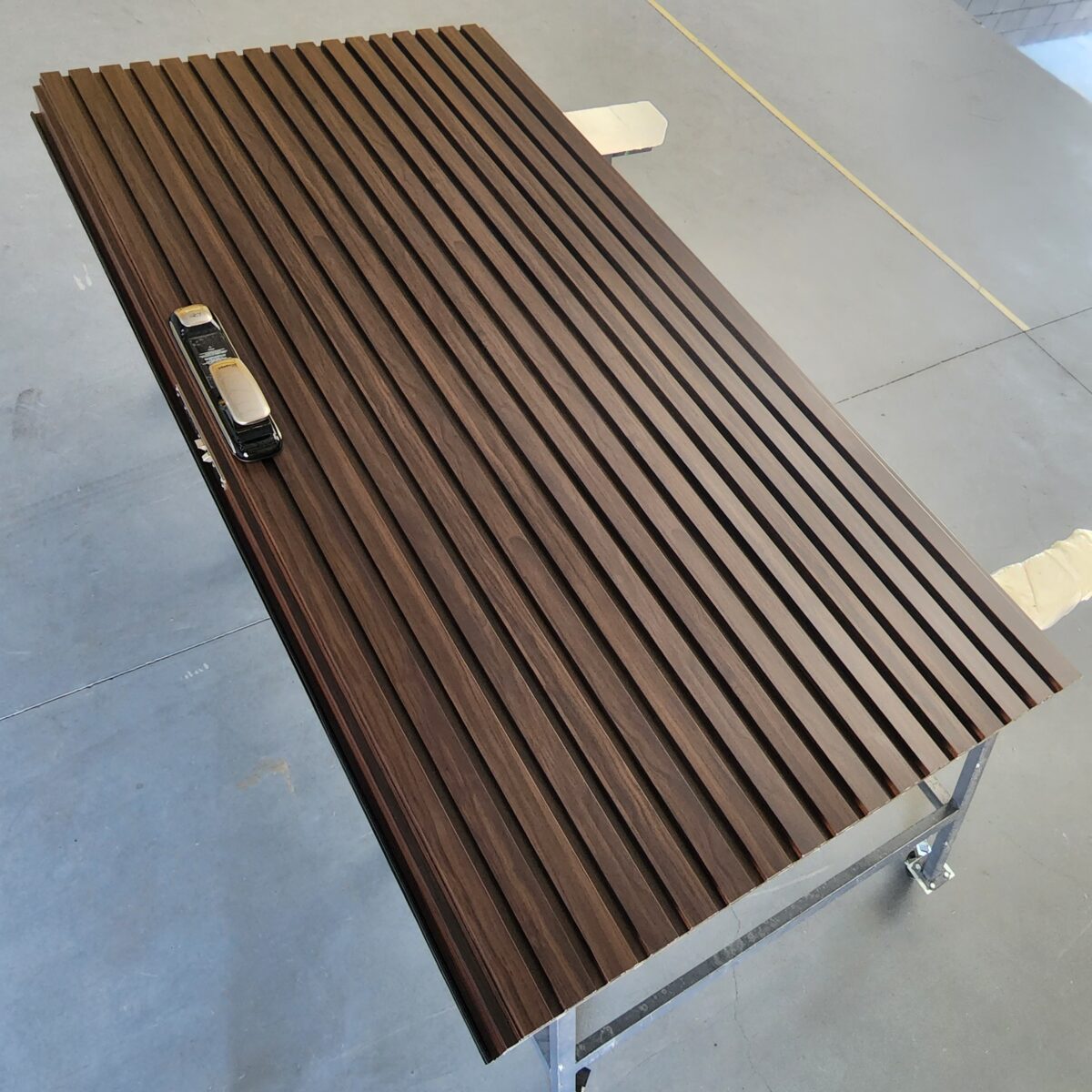 Porta pivotante em ACM ripado vertical, chapa Wood Sucupira, puxador cava e dupla vedação - Imagem 2