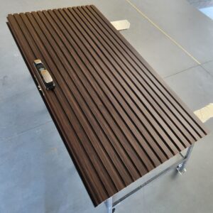 Porta pivotante em ACM ripado vertical, chapa Wood Sucupira, puxador cava e dupla vedação - Imagem 2