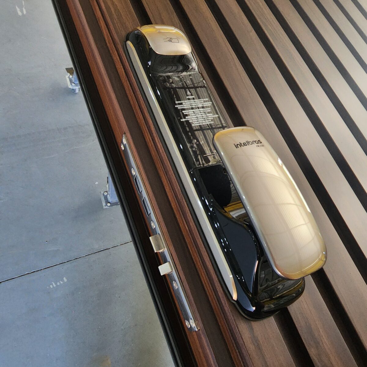 Porta pivotante em ACM ripado vertical, chapa Wood Sucupira, puxador cava e dupla vedação - Imagem 3