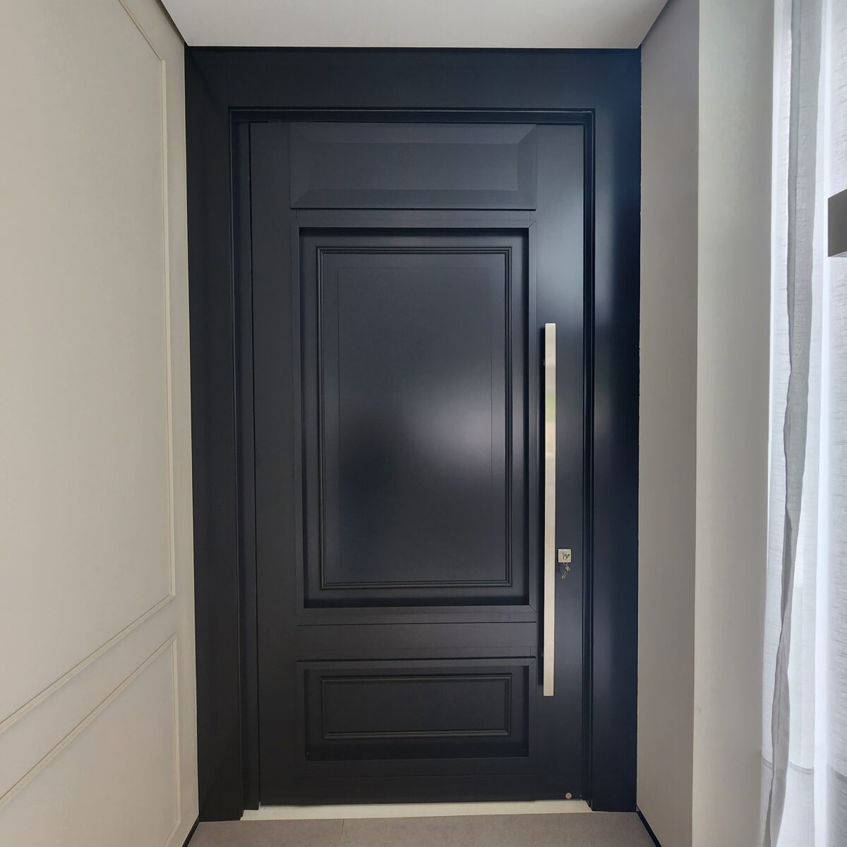 Porta pivotante em ACM preto fosco com detalhes exclusivos em almofadas 3D e boiseries - Imagem 6