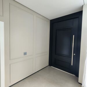 Porta pivotante em ACM preto fosco com detalhes exclusivos em almofadas 3D e boiseries - Imagem 7