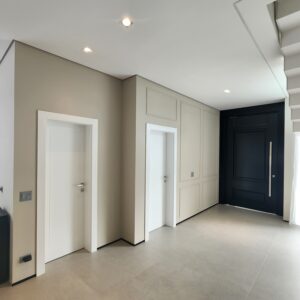 Porta pivotante em ACM preto fosco com detalhes exclusivos em almofadas 3D e boiseries - Imagem 8