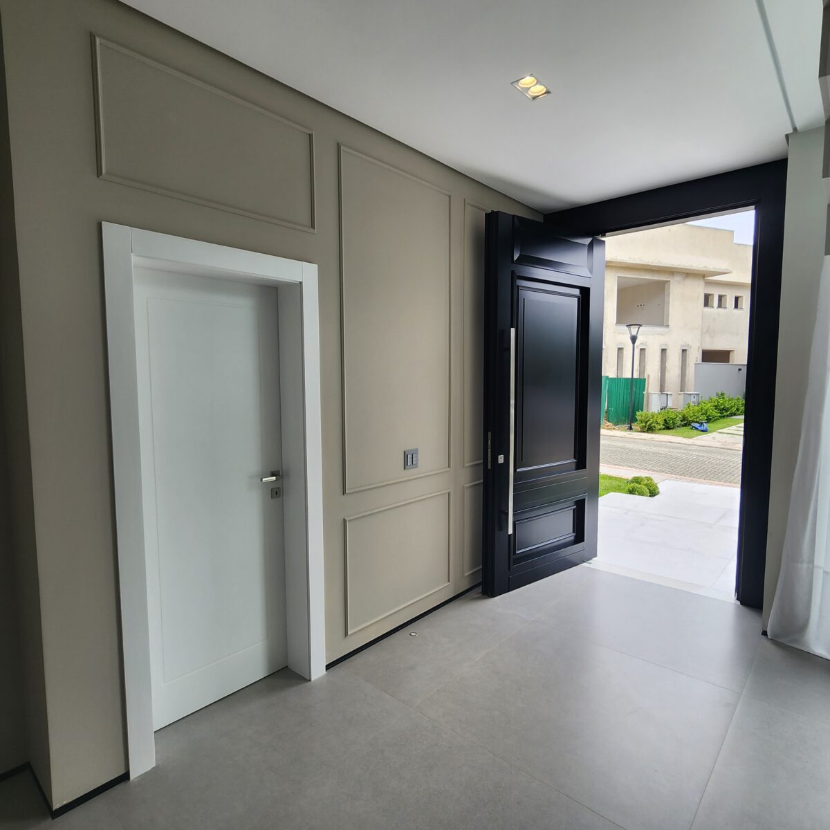 Porta pivotante em ACM preto fosco com detalhes exclusivos em almofadas 3D e boiseries - Imagem 10