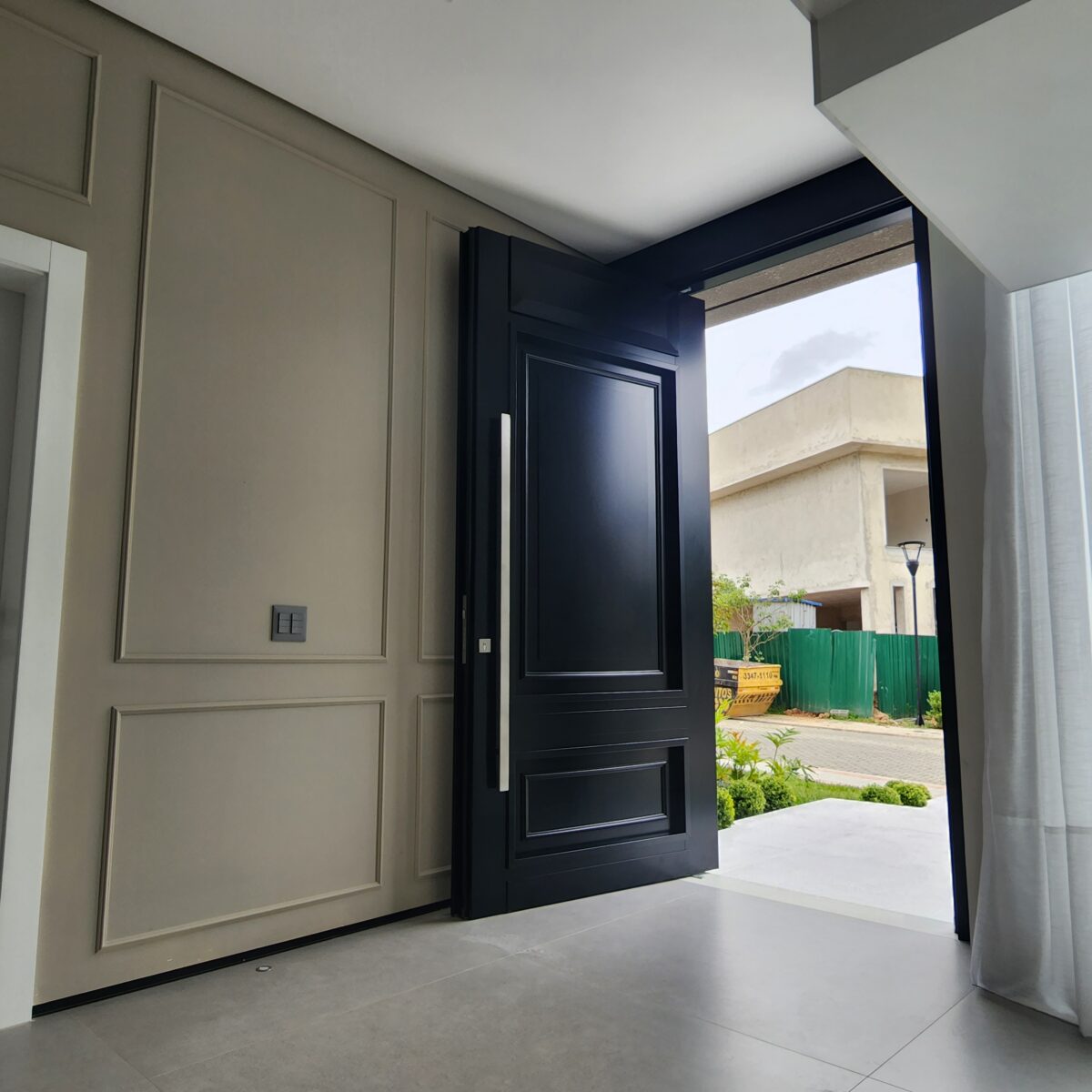 Porta pivotante em ACM preto fosco com detalhes exclusivos em almofadas 3D e boiseries - Imagem 11