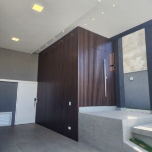 Porta pivotante em ACM ripado na vertical, painéis ripado seguindo alinhamento da porta, chapa Wood Sucupira - Imagem 2