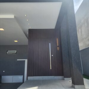 Porta pivotante em ACM ripado na vertical, painéis ripado seguindo alinhamento da porta, chapa Wood Sucupira - Imagem 5