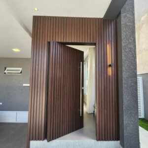 Porta pivotante em ACM ripado na vertical, painéis ripado seguindo alinhamento da porta, chapa Wood Sucupira - Imagem 6
