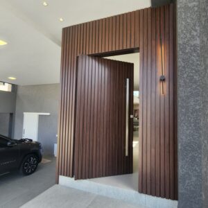 Porta pivotante em ACM ripado na vertical, painéis ripado seguindo alinhamento da porta, chapa Wood Sucupira - Imagem 7