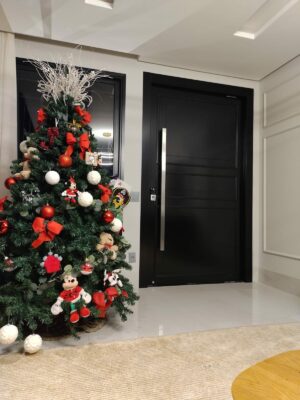 Porta pivotante em ACM preto fosco com boiseries e almofadas