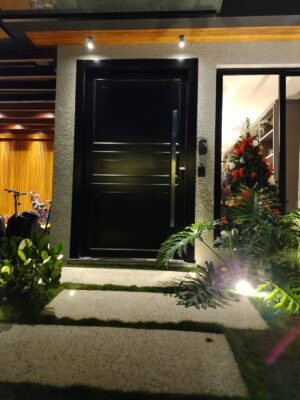 Porta pivotante em ACM preto fosco com boiseries e almofadas - Imagem 4