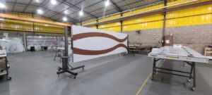 Porta pivotante em ACM branco neve com detalhe em mogno e dupla vedação porta e batente - Imagem 10