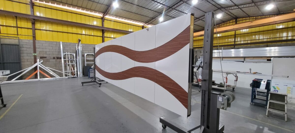 Porta pivotante em ACM branco neve com detalhe em mogno e dupla vedação porta e batente - Imagem 12