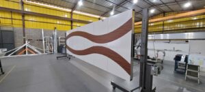 Porta pivotante em ACM branco neve com detalhe em mogno e dupla vedação porta e batente - Imagem 12