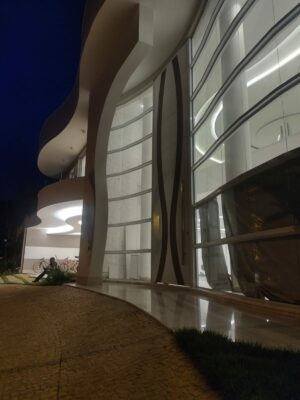 Porta pivotante em ACM branco neve com detalhe em mogno e dupla vedação porta e batente - Imagem 8