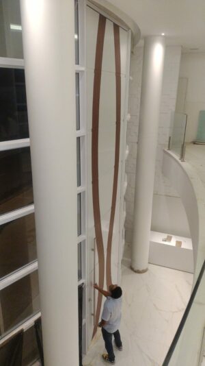 Porta pivotante em ACM branco neve com detalhe em mogno e dupla vedação porta e batente - Imagem 3