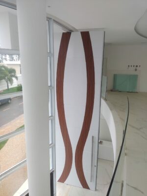 Porta pivotante em ACM branco neve com detalhe em mogno e dupla vedação porta e batente - Imagem 4