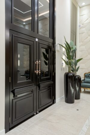 Porta em ACM preto fosco com sistema de abertura dupla, modelo neoclássico exclusivo. Design imponente, linhas sofisticadas e acabamento de alto padrão, ideal para projetos que valorizam elegância e modernidade - Imagem 2