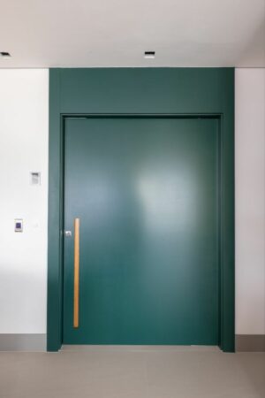 Porta pivotante em ACM liso com puxador cava e bandeira fixa