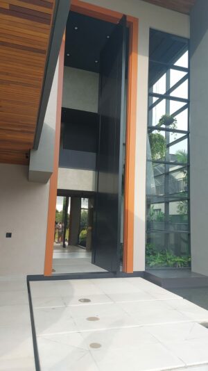 Porta pivotante em ACM preto fosco com puxador cava, batente e guarnições em ACM Wood Cerejeira - Imagem 2