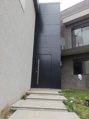 Porta pivotante em ACM preto fosco com painel e bandeira fixos