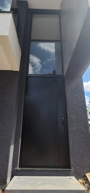 Porta pivotante em ACM preto fosco com puxador cava