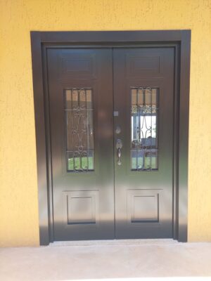 Porta em ACM preto fosco com sistema de abertura dupla, grade colonial de ferro
