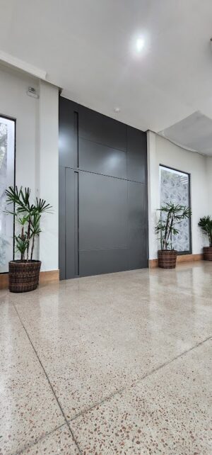 Porta pivotante em ACM Dark Grey com bandeira fixa e puxador cava