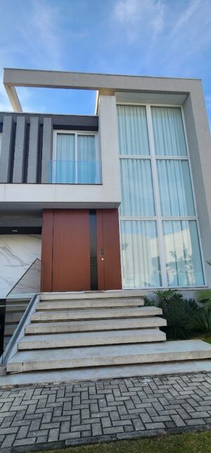 Porta pivotante em ACM com painéis fixos e puxador cava especial