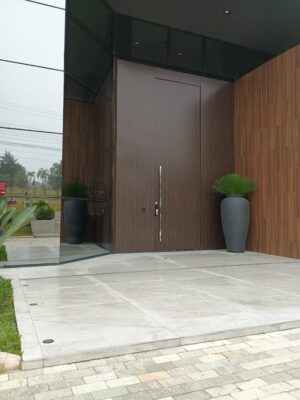 Porta pivotante em ACM Wood Sucupira com painéis fixos