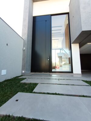 Porta em ACM preto fosco com puxador cava e portal lateral com vidro panorâmico