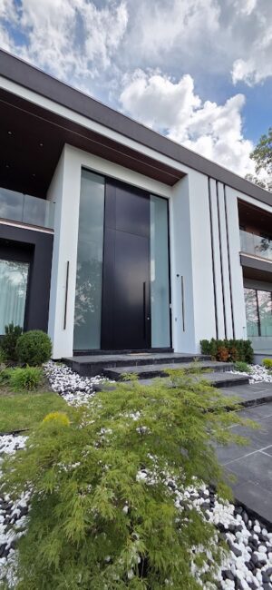 Porta pivotante em ACM preto fosco com portais duplos laterais em vidro. - Imagem 3