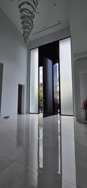 Porta pivotante em ACM preto fosco com portais duplos laterais em vidro. - Imagem 7