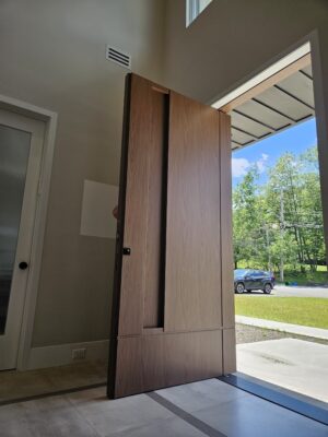 Porta pivotante em ACM Wood Nogueira com portais duplos laterais ripados, destacando elegância e contemporaneidade - Imagem 4